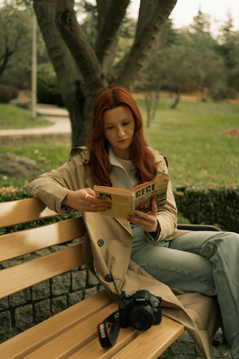 a woman sitting on a bench reading a book