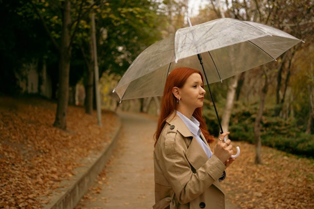a woman in a trench coat holding an umbrella