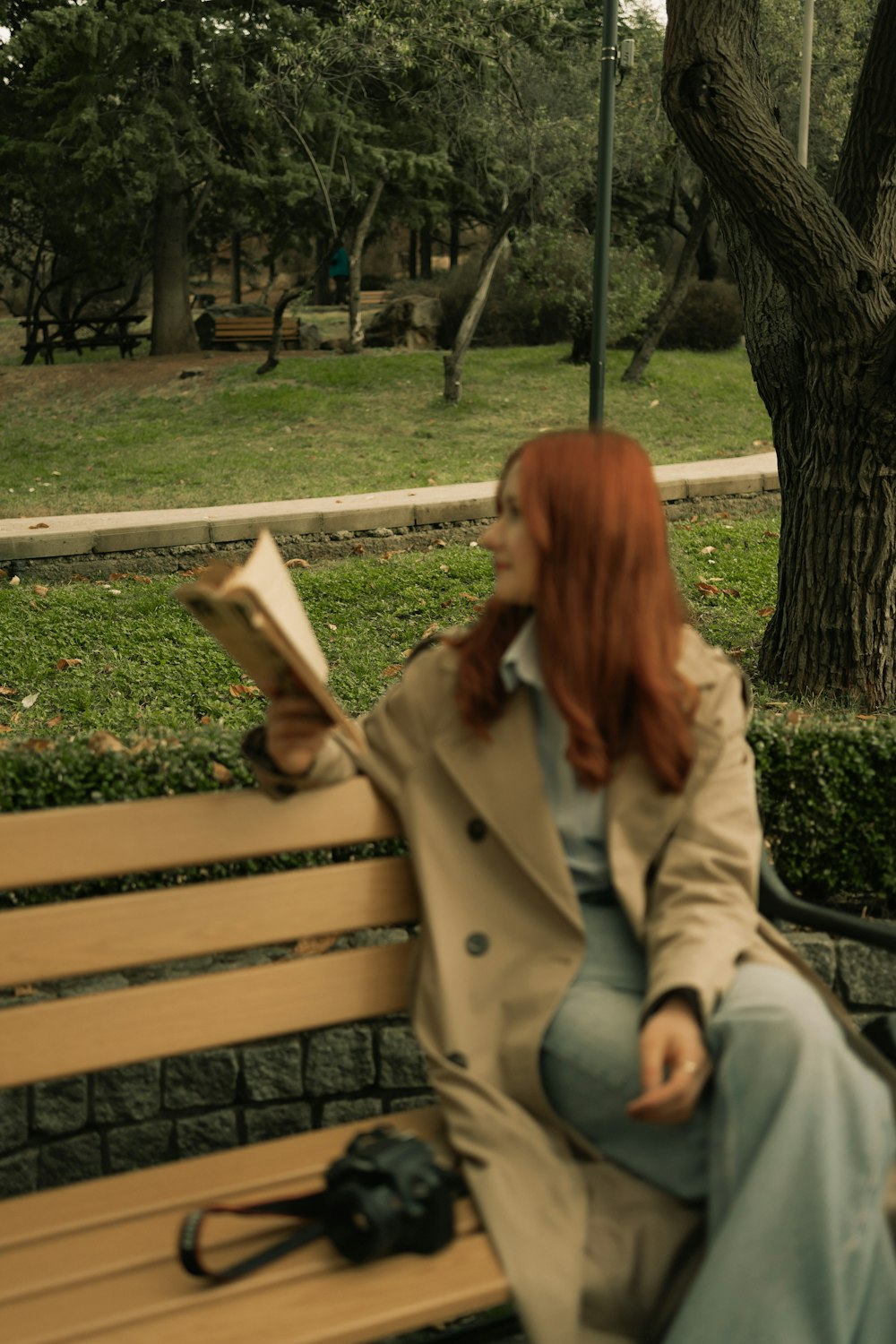 a woman sitting on a bench reading a book