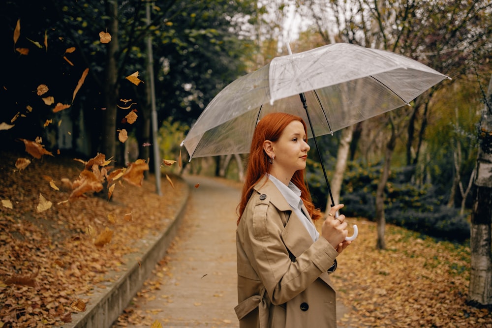 a woman in a trench coat holding an umbrella