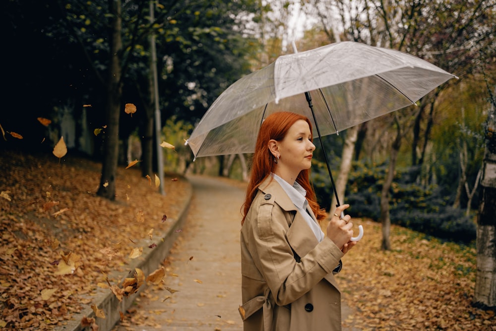 a woman in a trench coat holding an umbrella