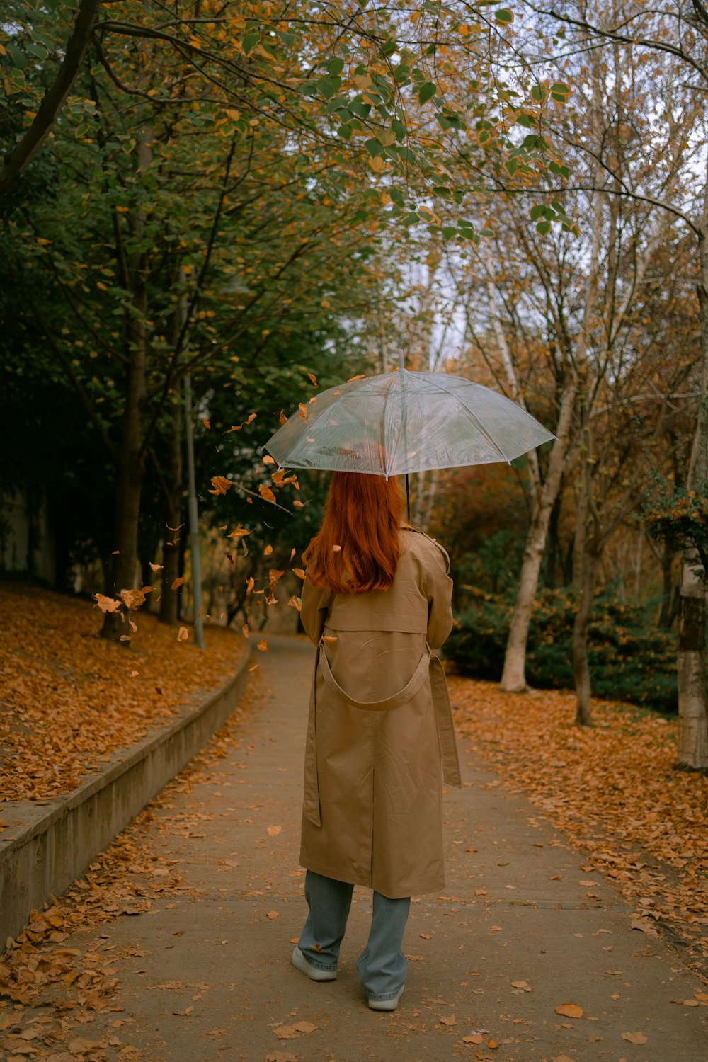 a woman walking down a path holding an umbrella