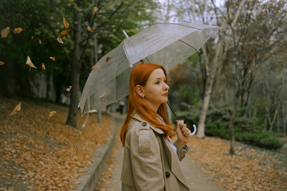 a woman with red hair is holding an umbrella