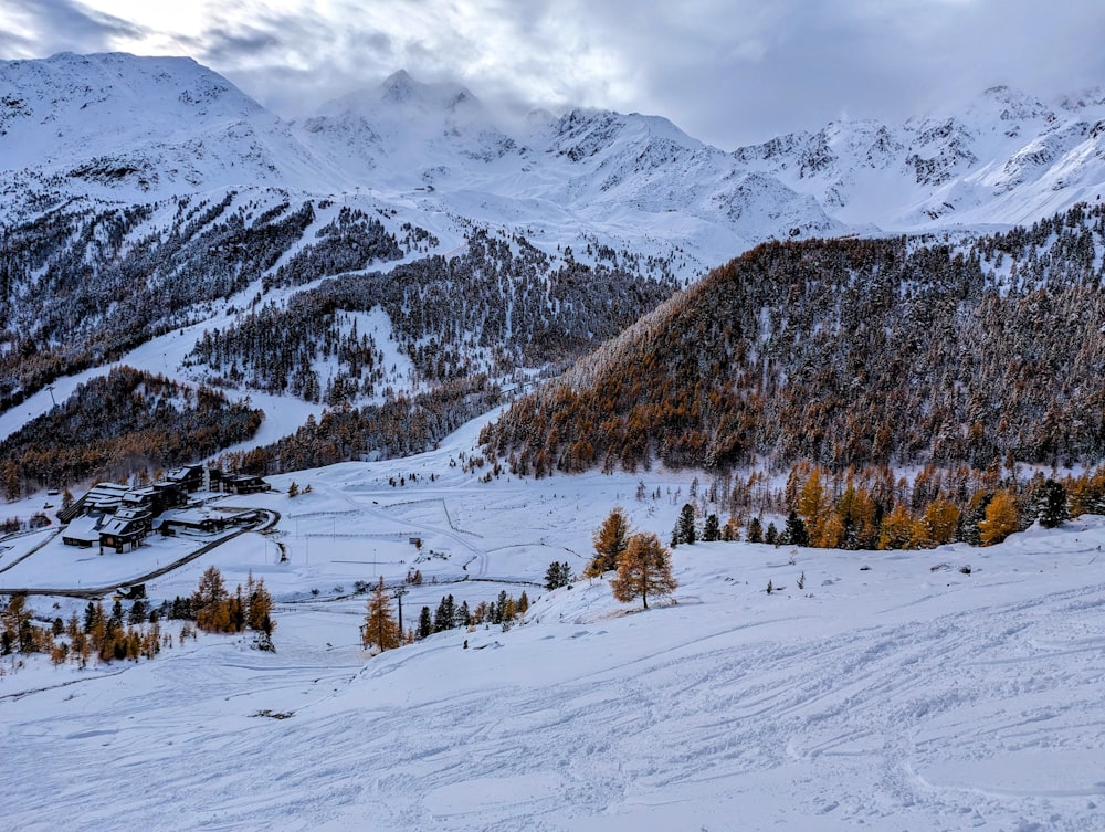 a snow covered mountain with a ski resort in the distance