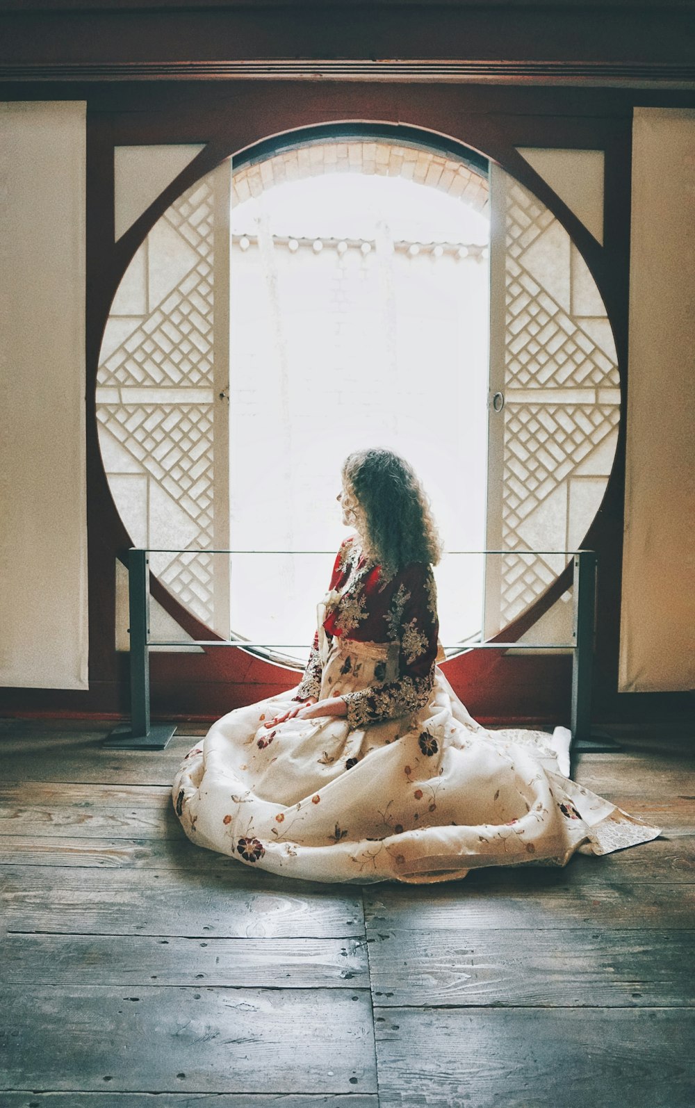 a woman sitting on the floor in front of a window