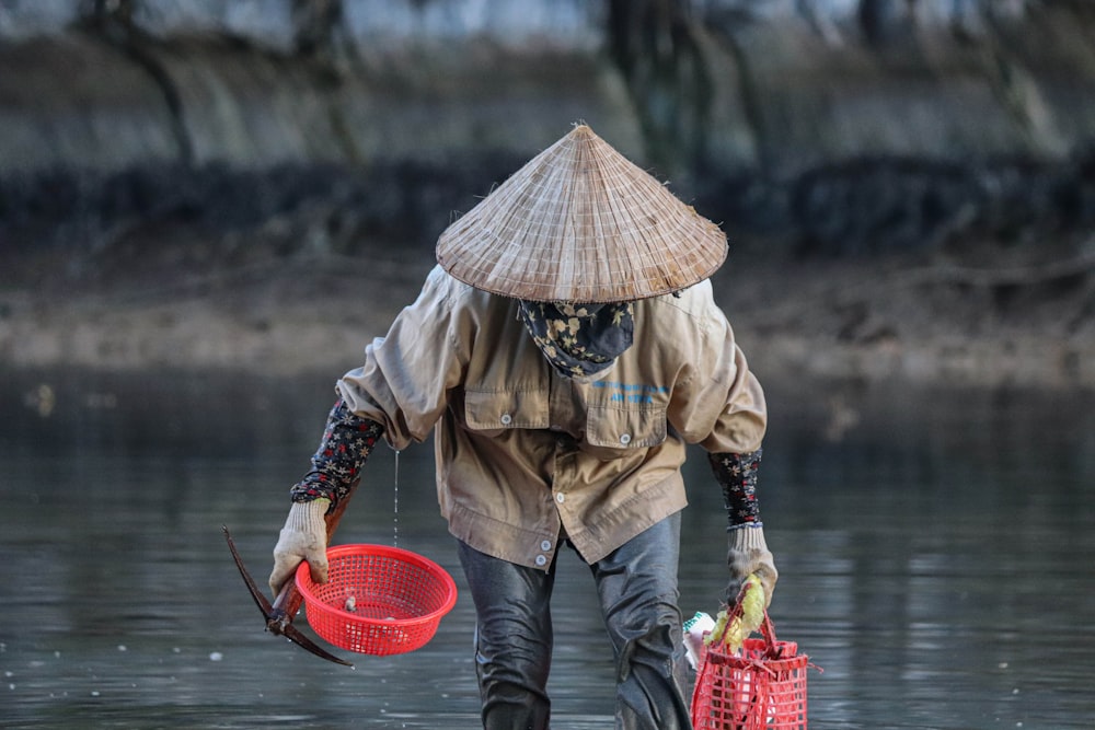 a person walking in water with a red basket