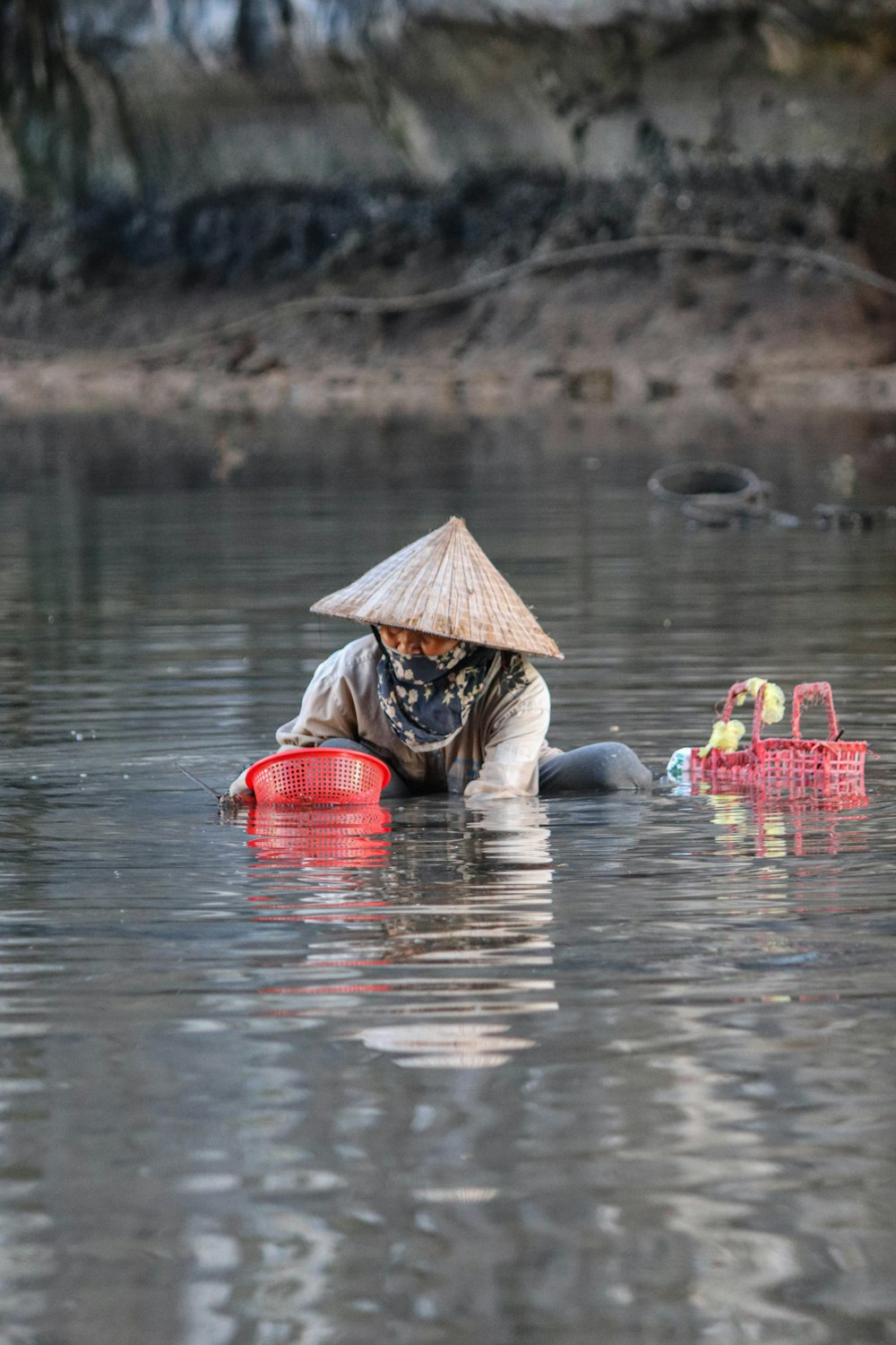 Une femme coiffée d’un chapeau de paille est dans l’eau