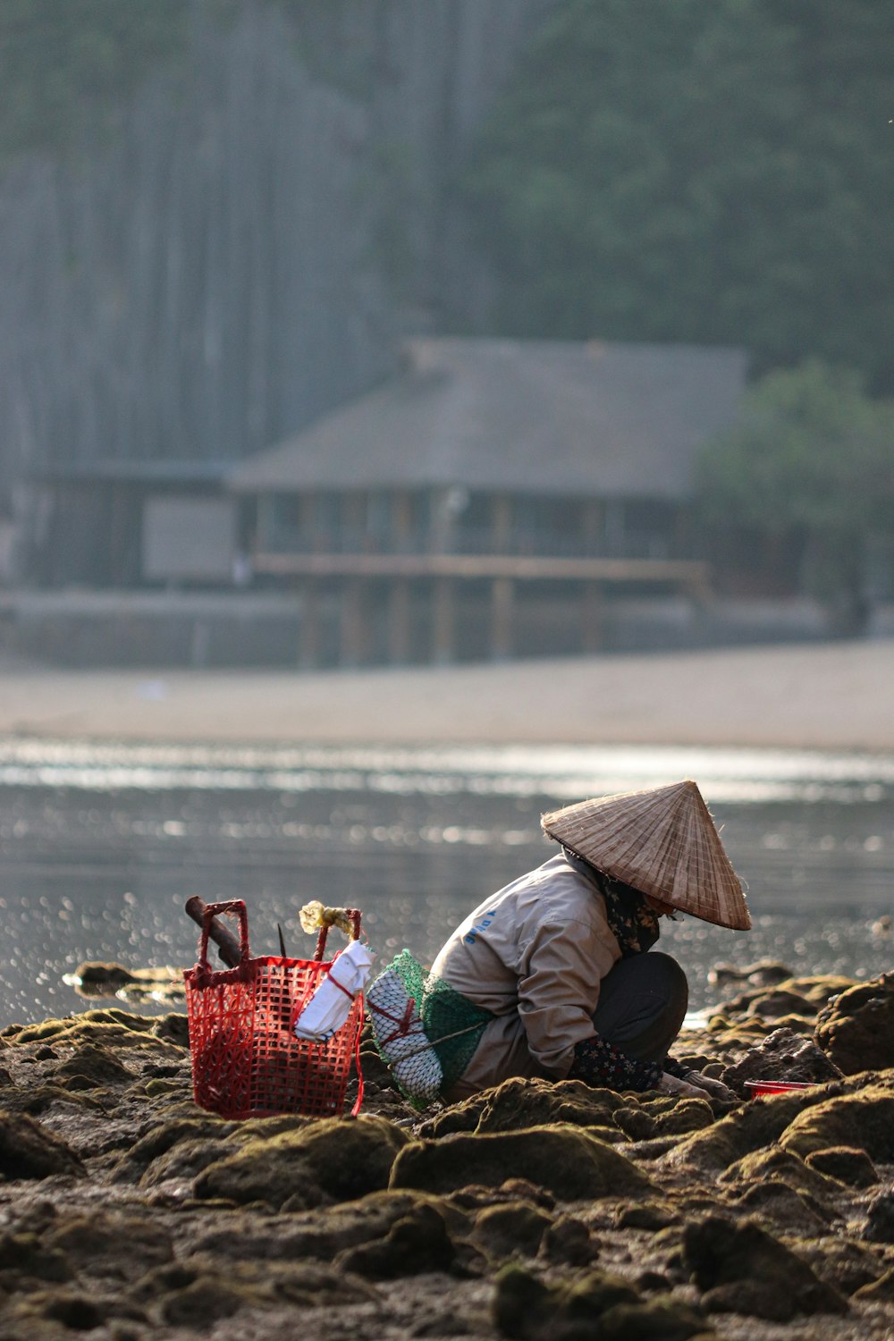 eine Person, die mit einem Korb am Strand sitzt