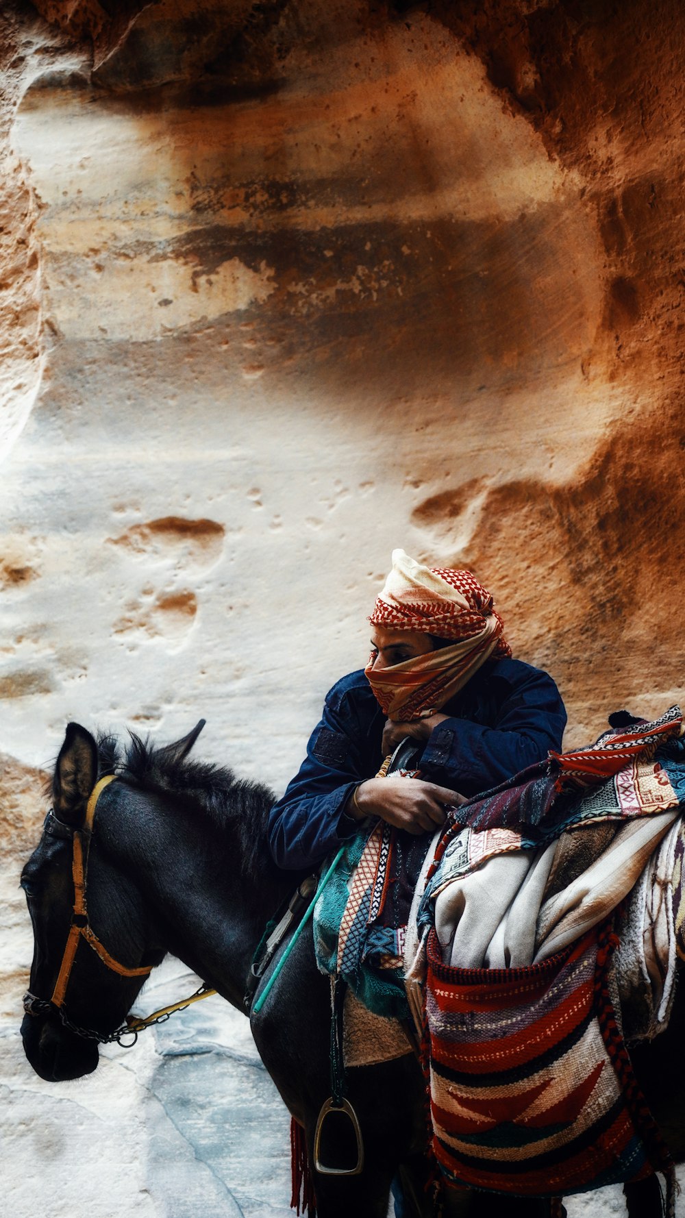 a man sitting on a horse in a canyon