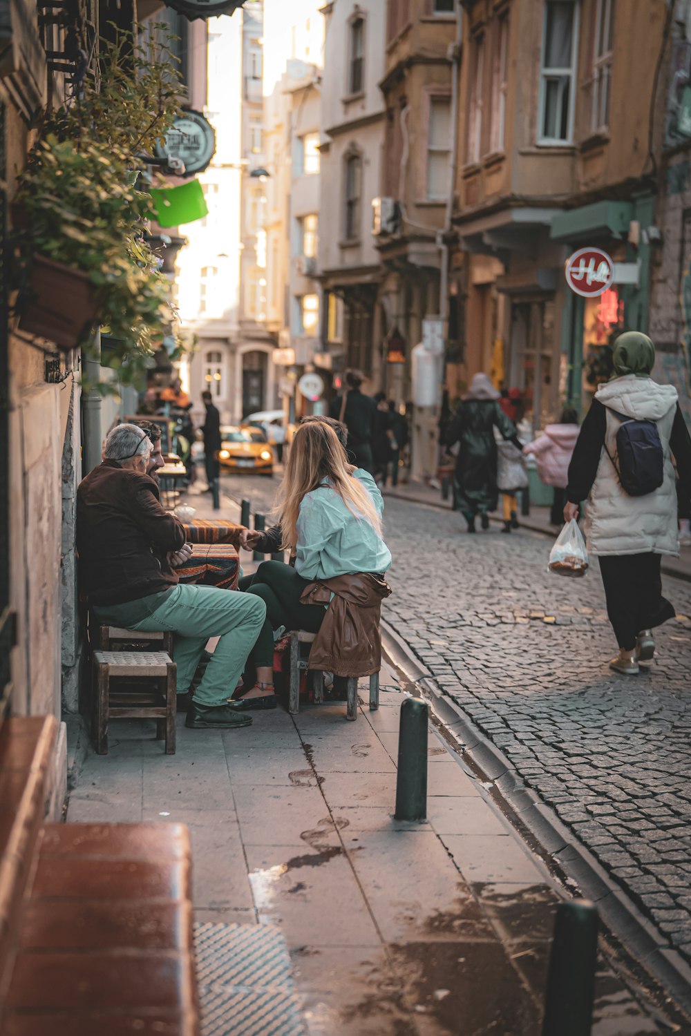 a couple of people sitting at a table on a sidewalk