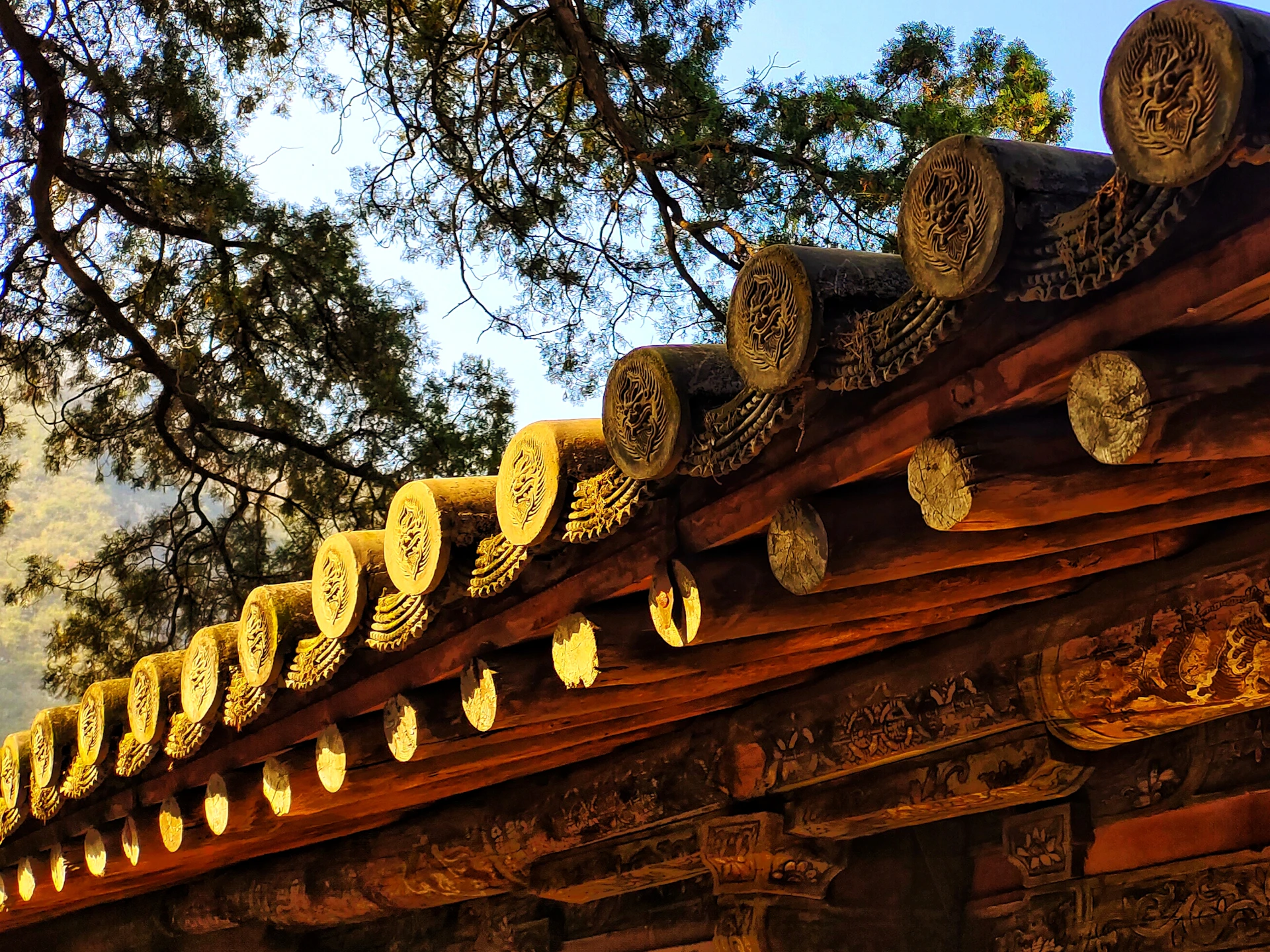 Traditional Kathkuni timber architecture details with warm sunlight filtering through carved wooden beams.
