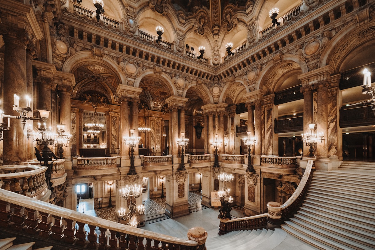a grand staircase in a building with chandeliers