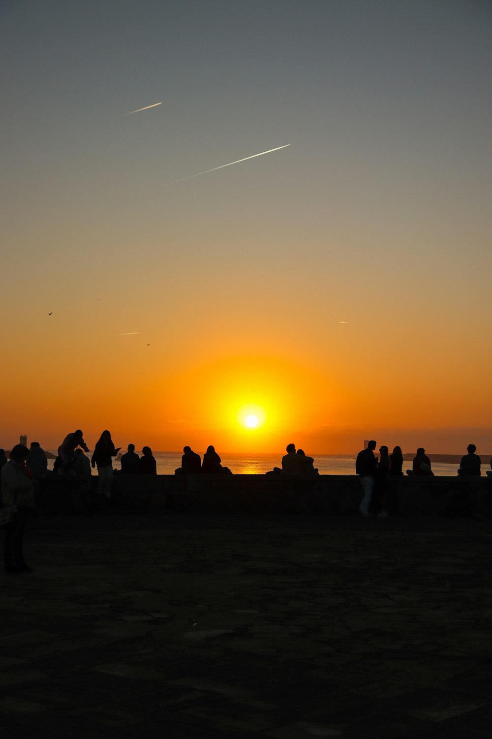 a group of people standing on top of a sandy beach