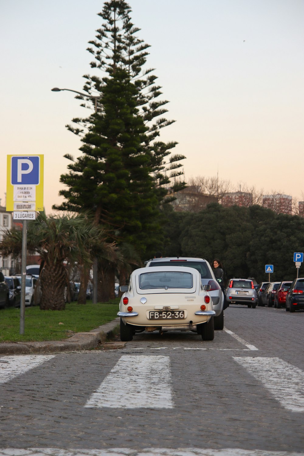 a white car is parked on the side of the road