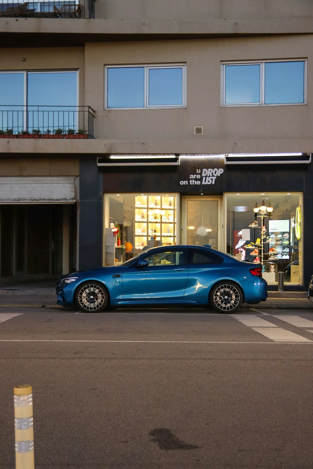 a blue car parked in front of a building