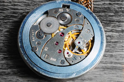 Close-up of a vintage mechanical watch movement with intricate gears and springs.