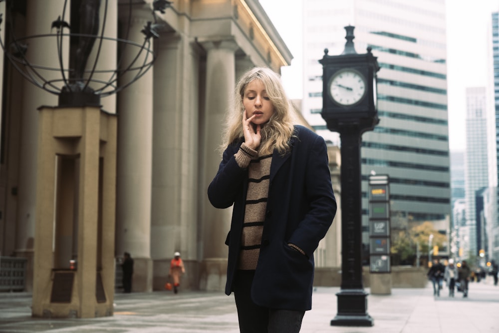 a woman is walking down the street talking on her cell phone