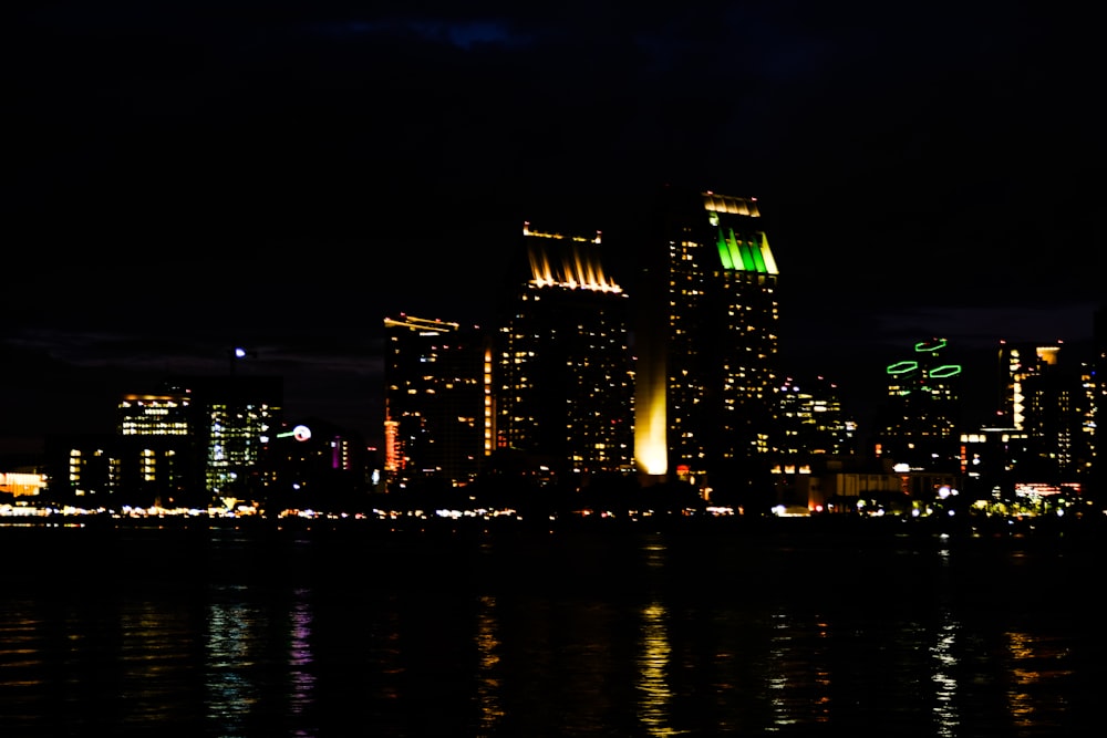 a city skyline at night with lights reflecting in the water