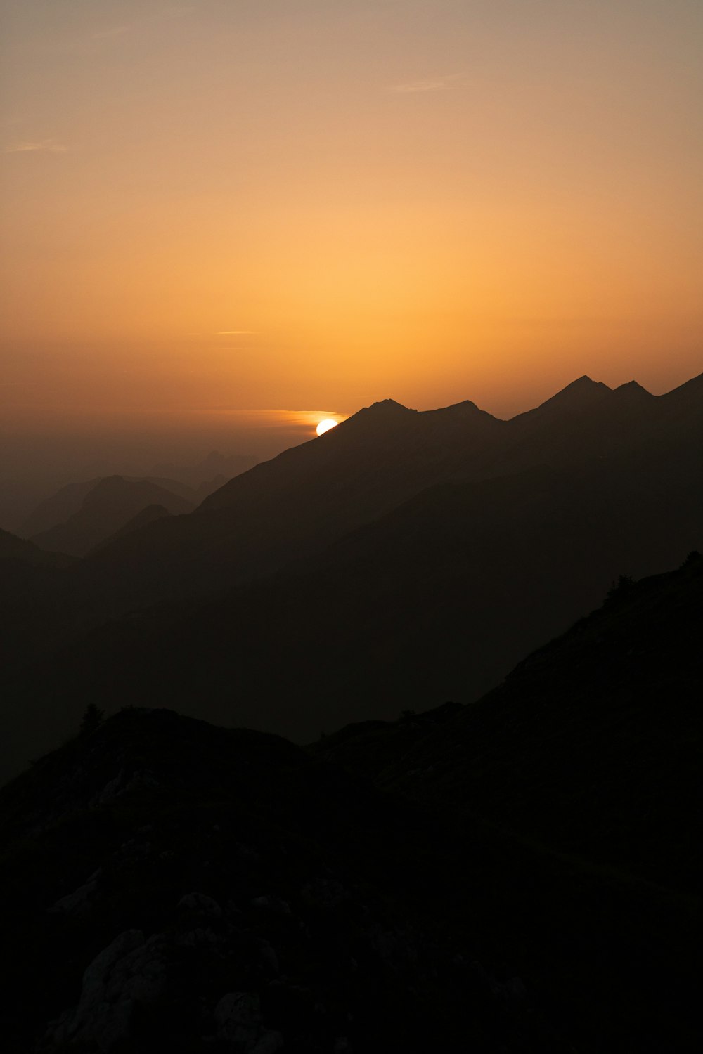 Die Sonne geht über einer Bergkette unter