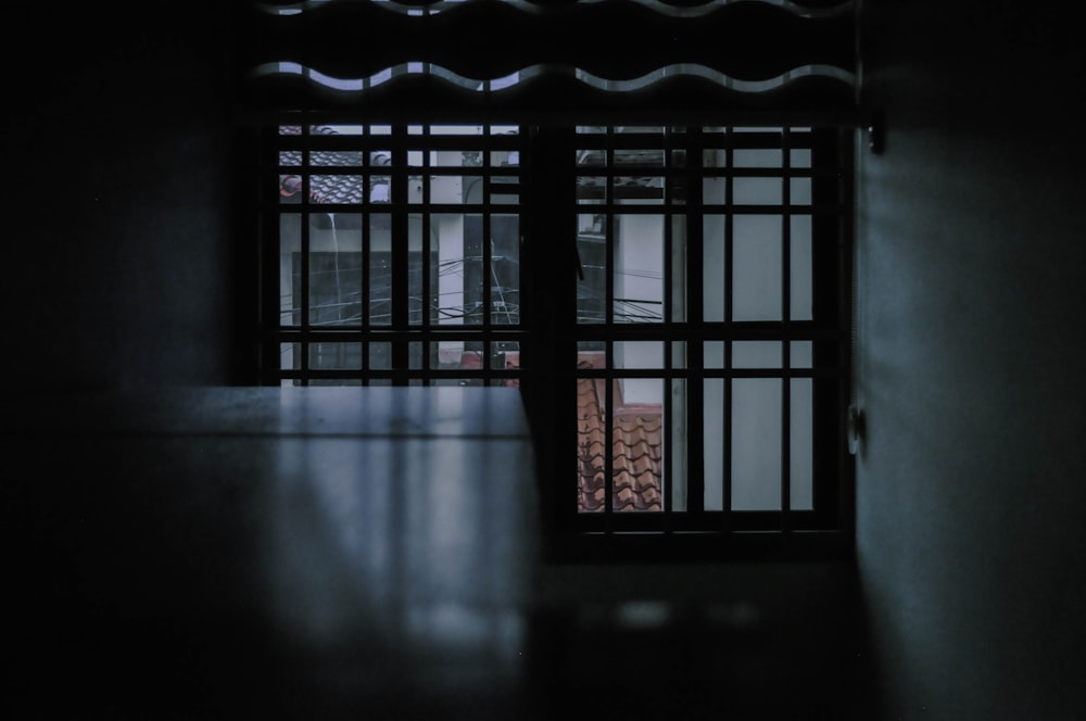 a dark room with a window that has bars on it