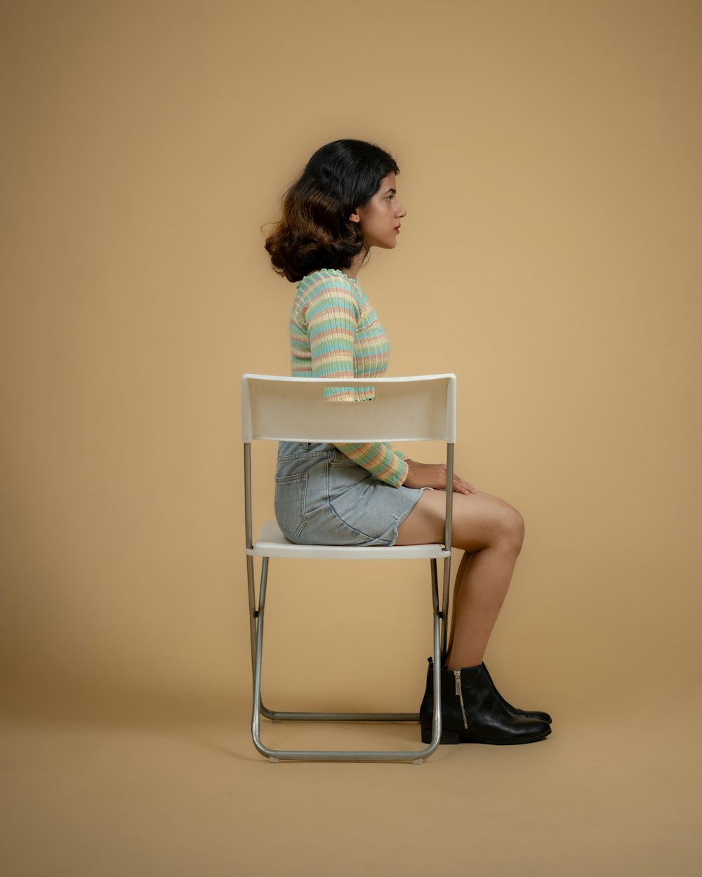 a woman sitting on a chair with her legs crossed