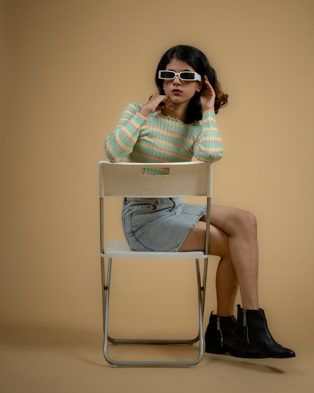 a woman sitting in a chair with her hand on her head