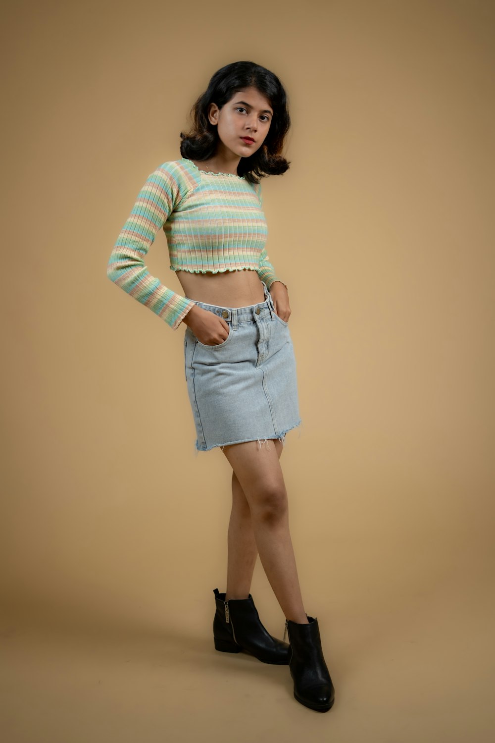 a woman in a striped shirt and denim skirt