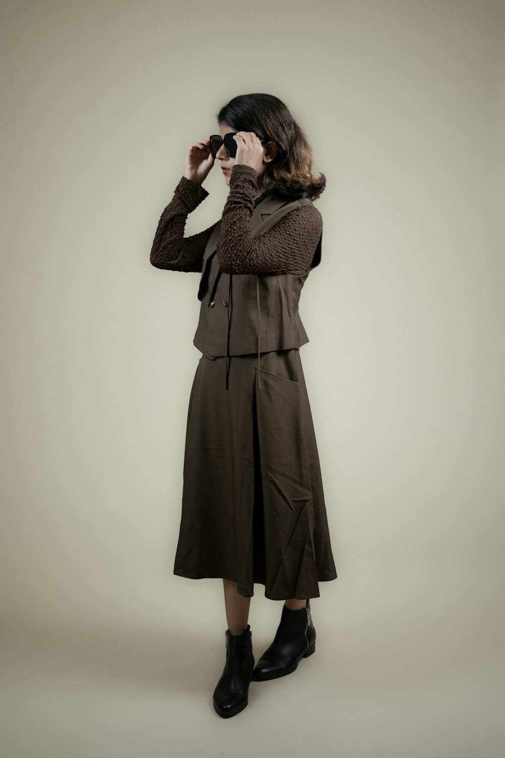 a woman in a trench coat looking through binoculars
