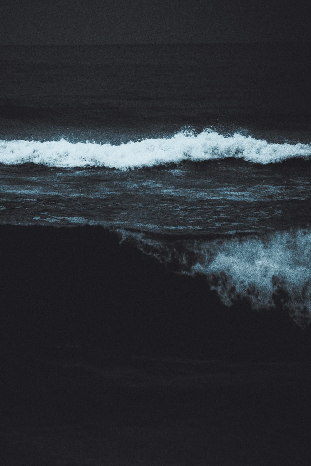 a black and white photo of a wave in the ocean