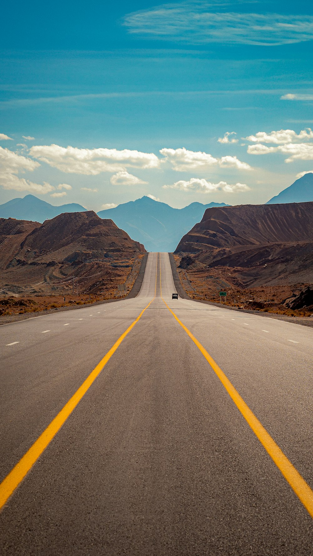 an empty road with a yellow line on the middle of it