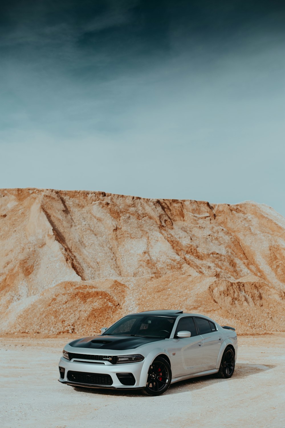 um carro branco estacionado em frente a uma montanha