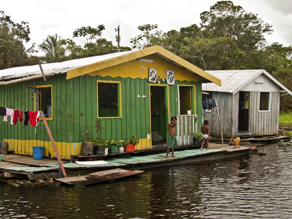 a green house sitting on top of a body of water