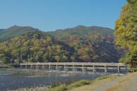 a bridge over a river in front of a mountain