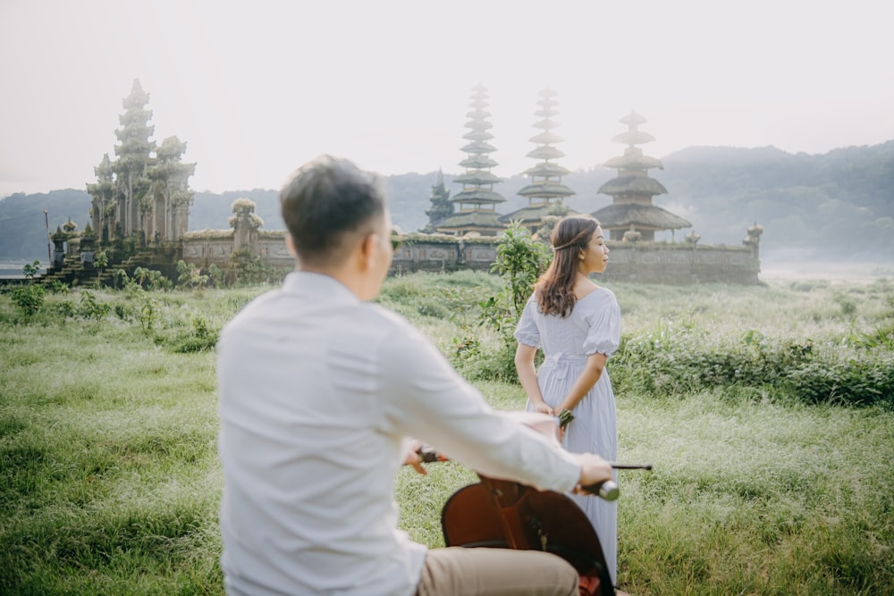 a man and a woman riding on the back of a bike