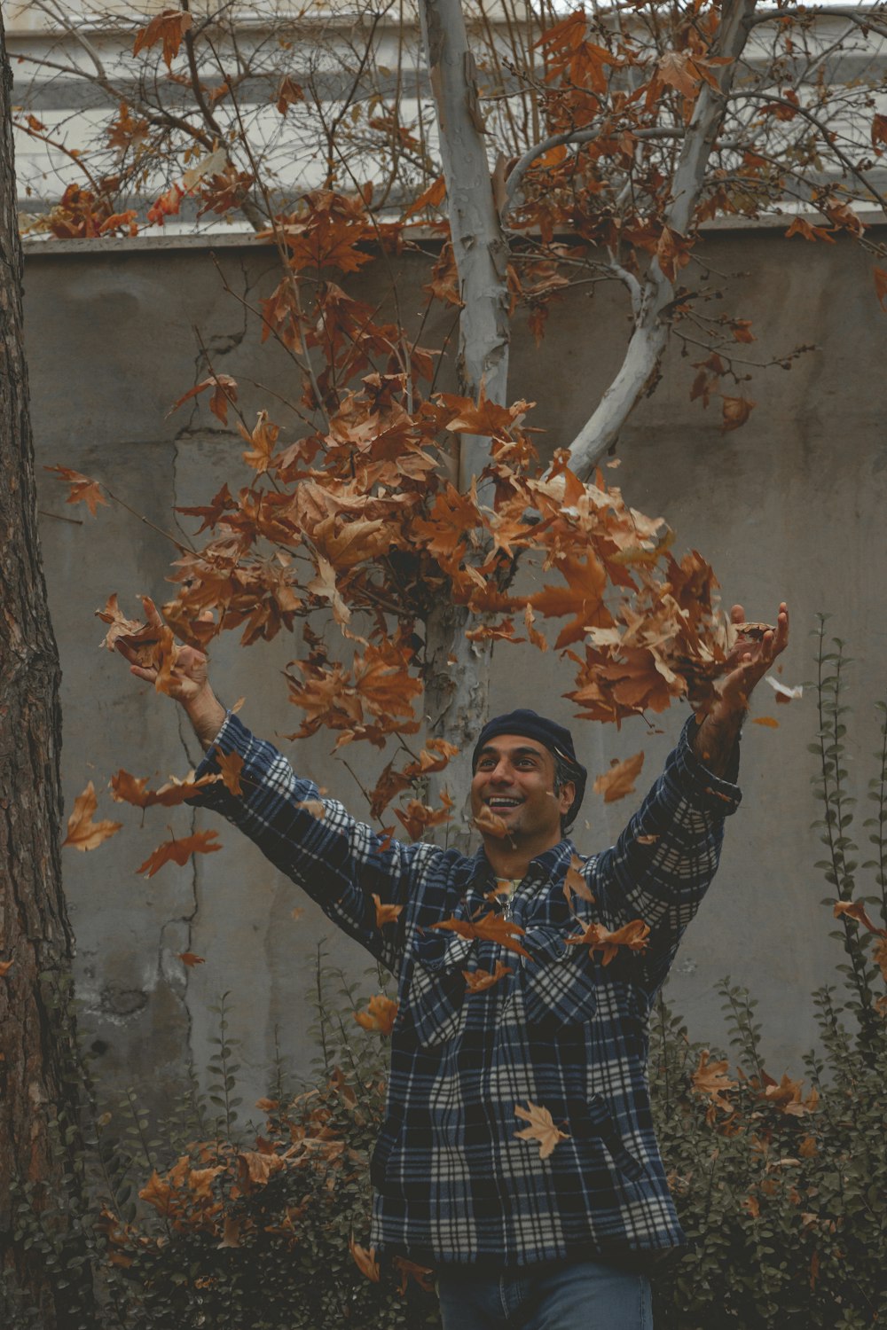 a man is throwing leaves in the air