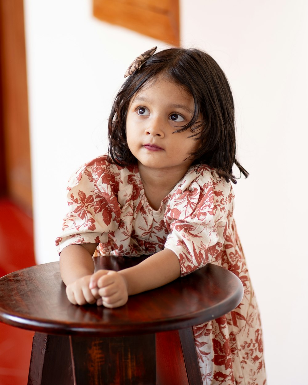 a little girl that is sitting on a stool