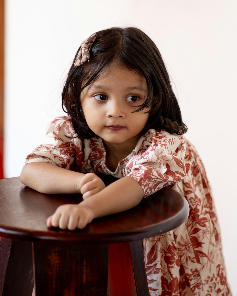a little girl sitting at a wooden table