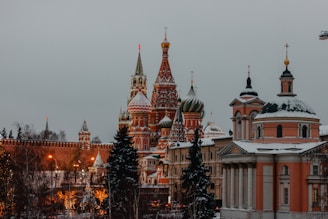 Snow-covered domes of Saint Basil’s Cathedral in Moscow glowing warmly at sunset.