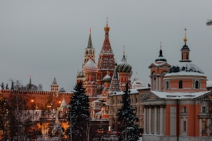 Snow-covered Russian architecture glowing softly at dusk with travelers admiring the view