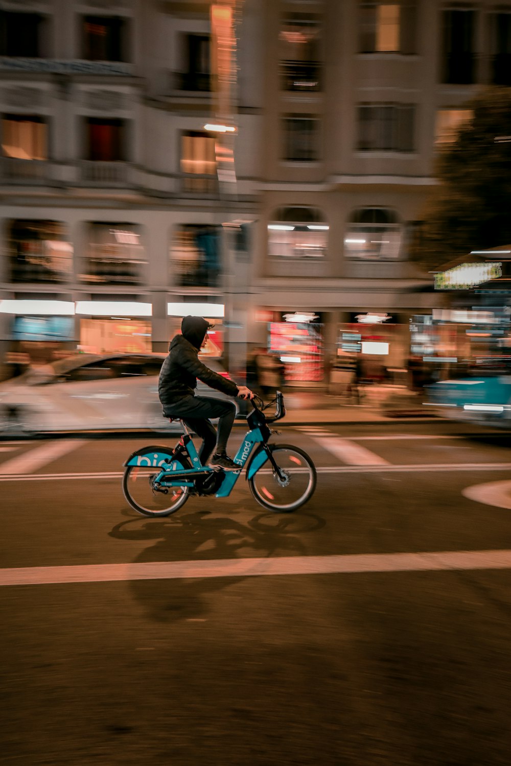 a man riding a bike down a street at night