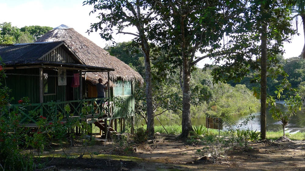 a hut with a thatched roof next to a river