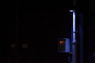Close-up of high-tech leak detection devices with glowing indicators in a dark corporate setting.