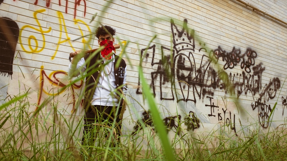 a man standing in front of a wall covered in graffiti