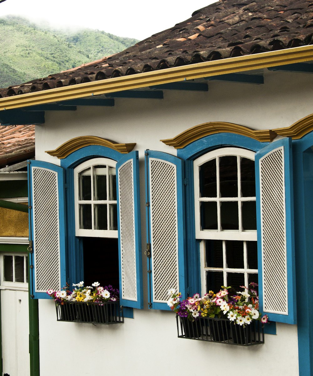 a white building with blue windows and shutters