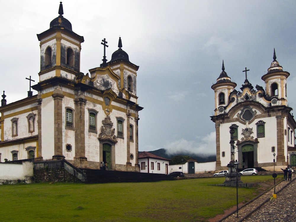 a couple of large buildings sitting on top of a lush green field