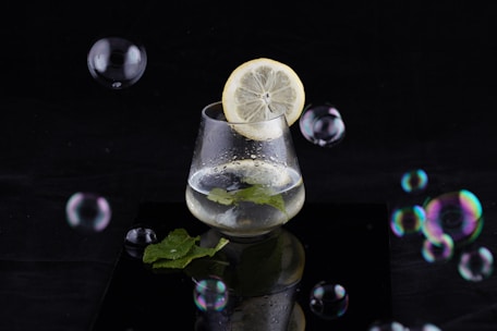 Close-up of a glass of infused water with fresh lemon and mint leaves.