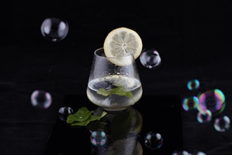 Close-up of a glass of infused water with lemon and mint leaves.