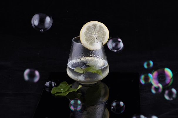 Close-up of a glass of infused water with lemon and mint, representing hydration.