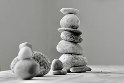 Close-up of smooth stones stacked in balance on a soft beige surface.