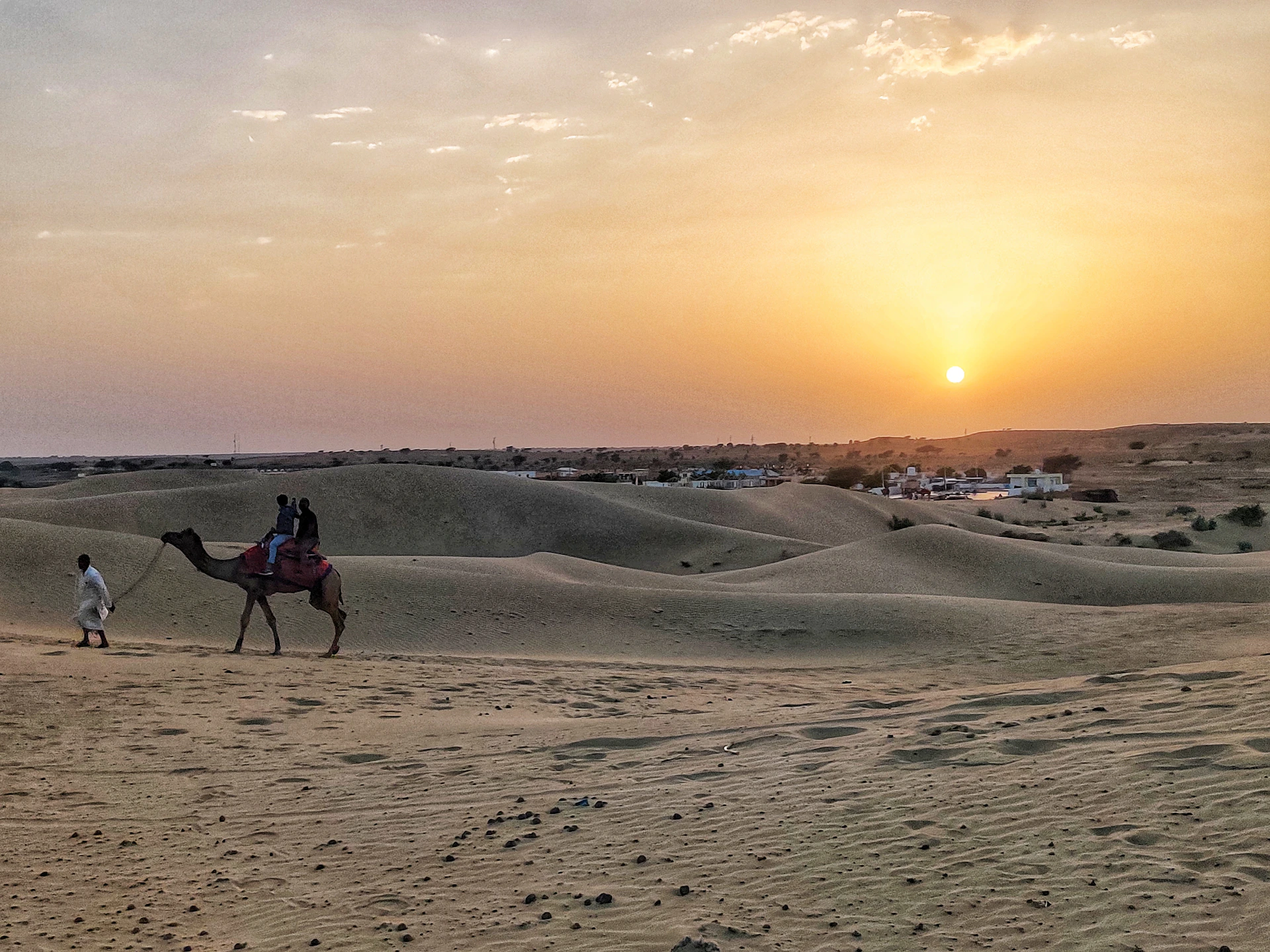two people riding a camel in the desert
